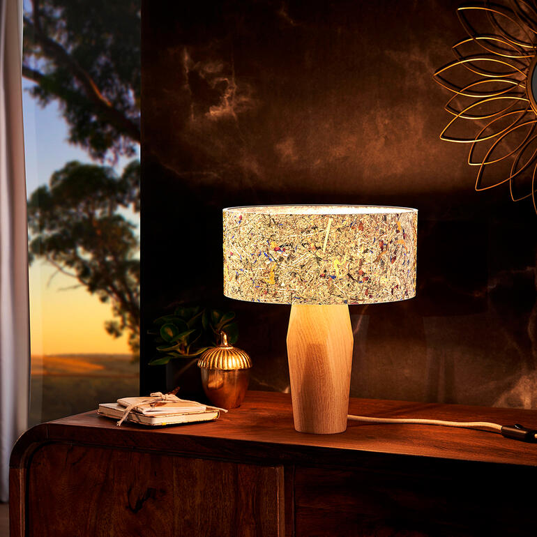 Lampe de table moderne en bois de pin avec un abat-jour coloré sur une commode