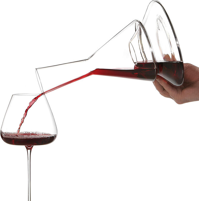 Le vin rouge est versé d'une décanter Doppio à deux niveaux dans un verre.