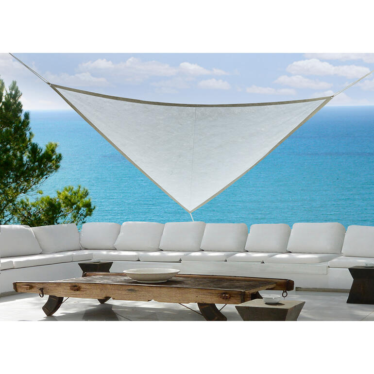 Voile solaire au-dessus d'un mobilier de terrasse moderne près de la mer