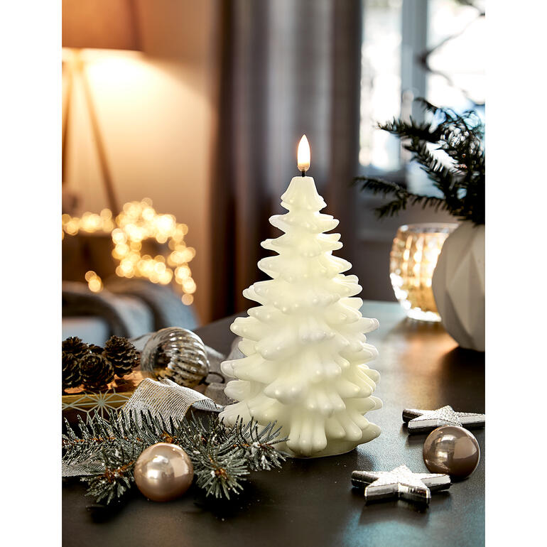 Bougie LED couleur ivoire en forme de sapin, décorée sur une table.