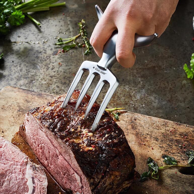 Main tenant Bull Fork pour couper un morceau de viande.