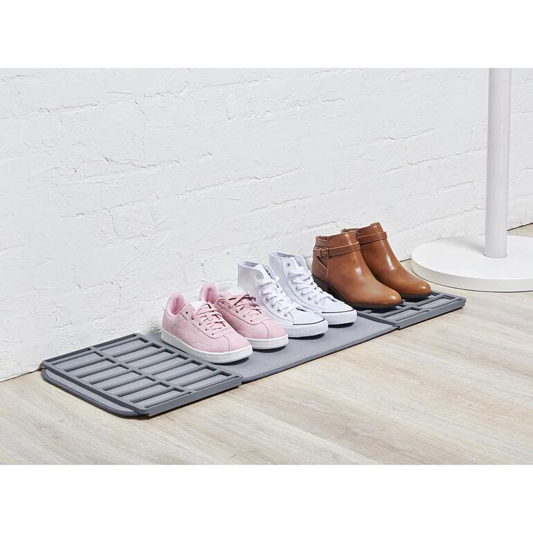 Étagère à chaussures pliable avec différentes chaussures dessus, espace pour plusieurs paires.