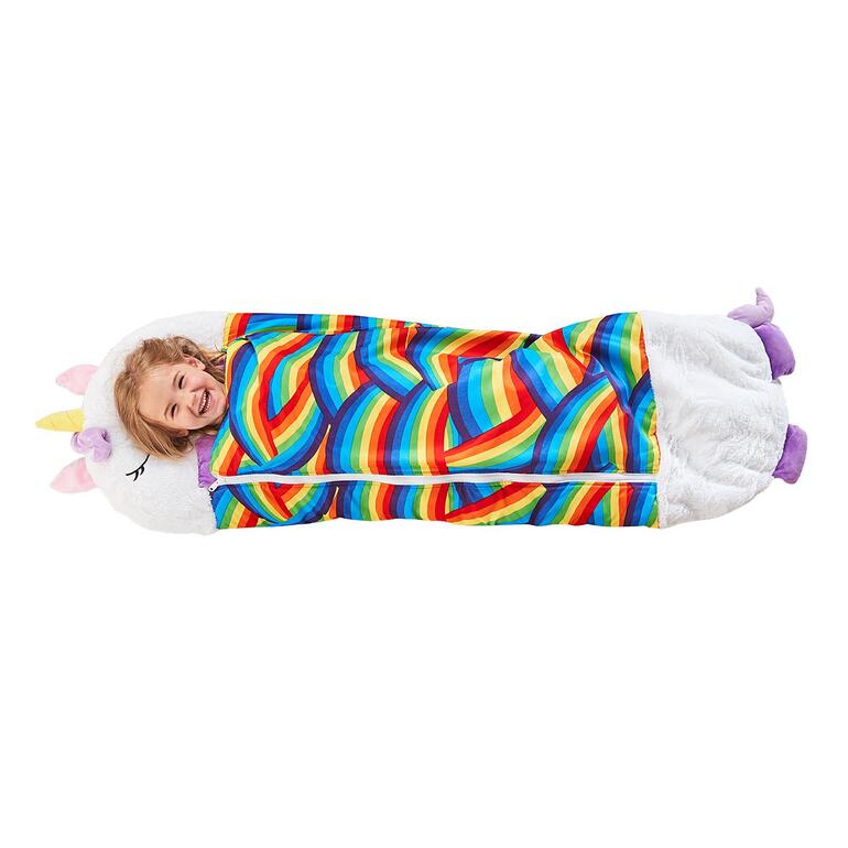 Oreiller en peluche licorne avec sac de couchage arc-en-ciel. Fille souriante dans un sac de couchage en forme d'unicorne aux couleurs arc-en-ciel.