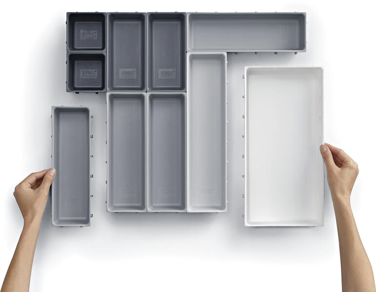 Organisateur de tiroir modulaire avec différents insertions sur fond blanc.