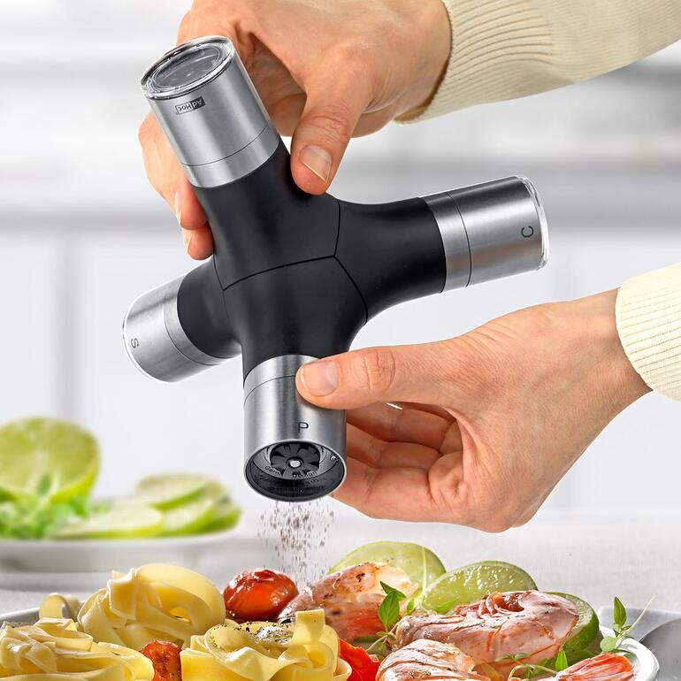 Moulin à épices AdHoc en action, des épices sont saupoudrées sur un plat.