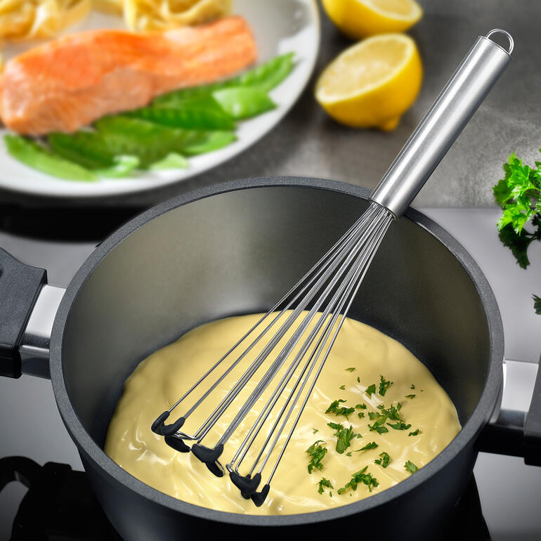 Fouet en acier dans une casserole avec de la crème