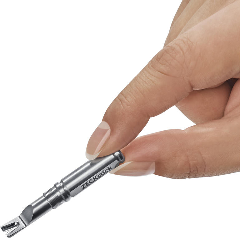 Main tenant le ZECKstick, un stylo argenté pour retirer les tiques.