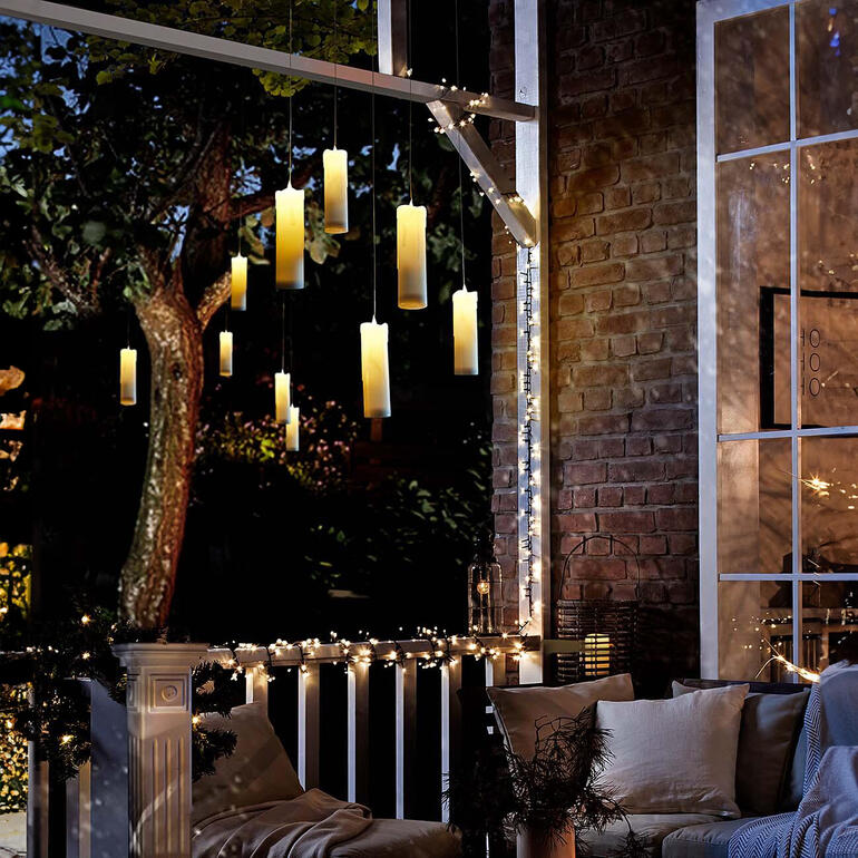 Bougies LED suspendues sur une terrasse avec des lumières.