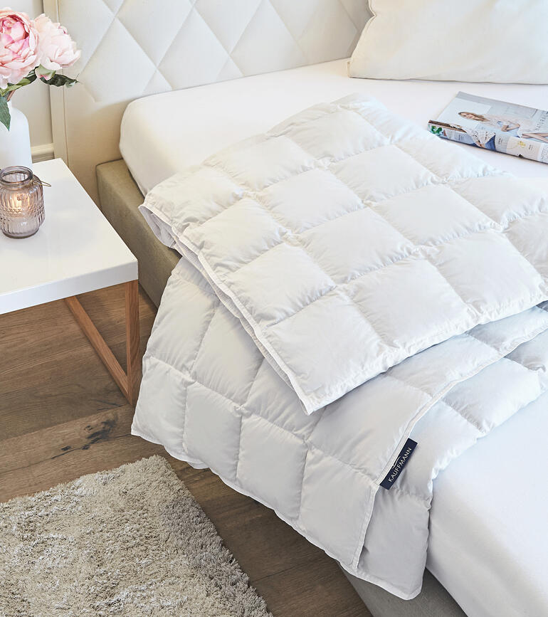 Couette légère en duvet d'eider sur un lit avec des coussins