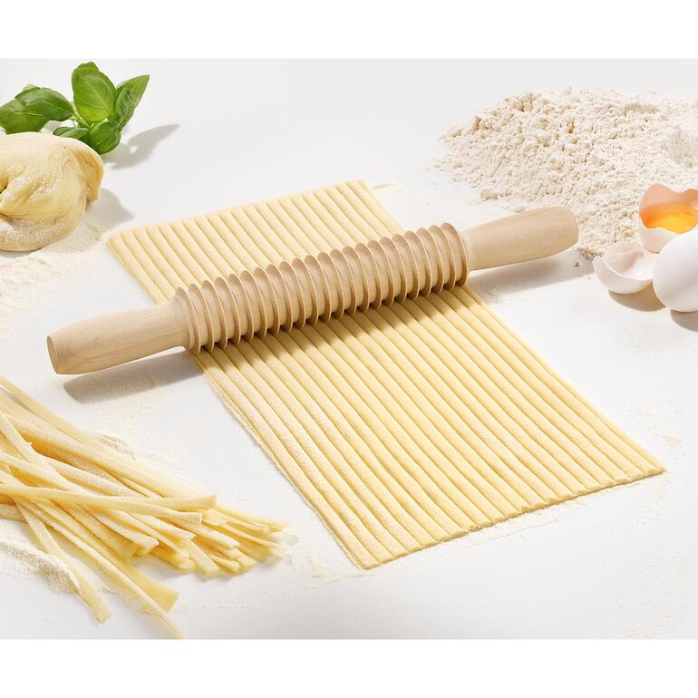 Coupe-spaghetti ou fettuccine en bois sur une surface de travail propre.