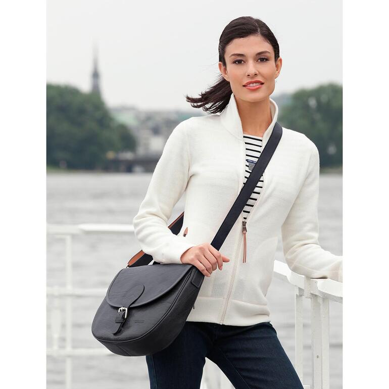 Femme avec un sac de steward noir au bord de l'eau.