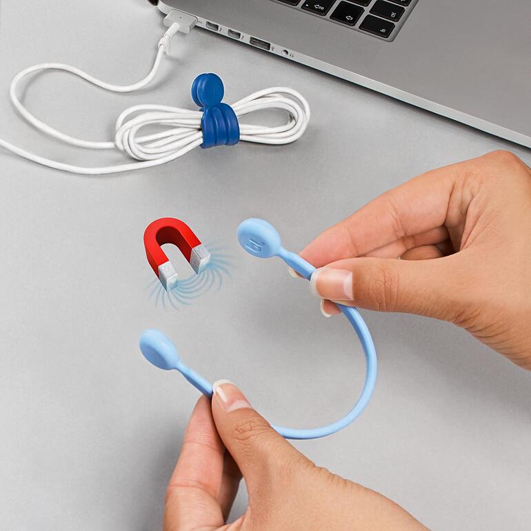 Des mains tiennent un serre-câble magnétique bleu à côté d'un câble enroulé.