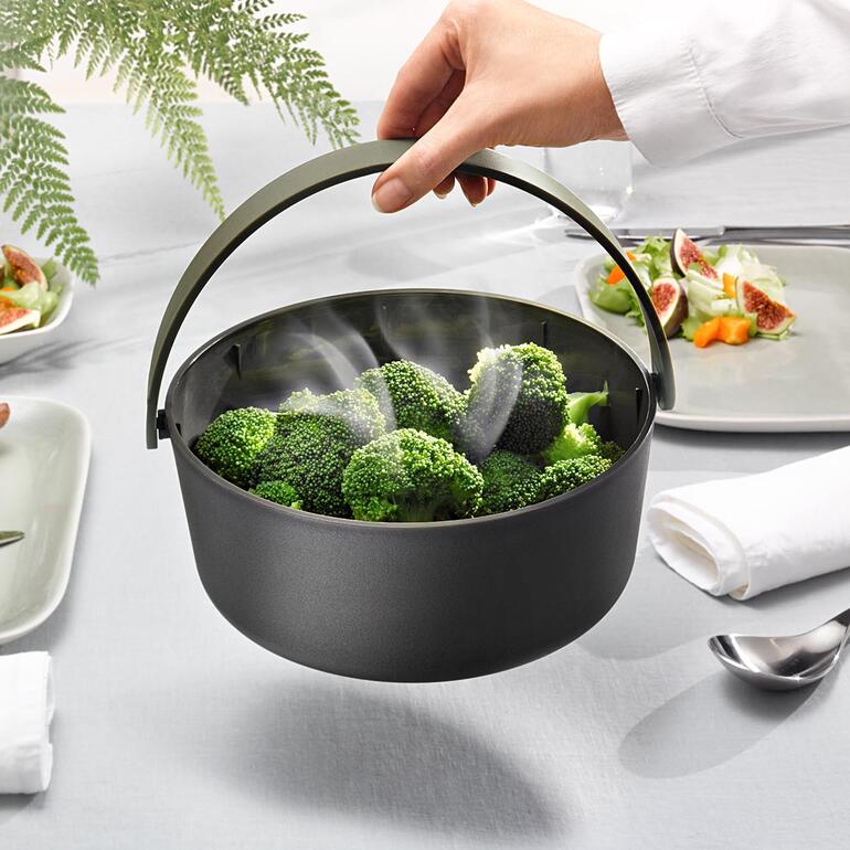 La poignée ne chauffe pas : le cuiseur vapeur peut donc être transporté facilement. Cuiseur vapeur pour micro-ondes avec poignée servant du brocoli