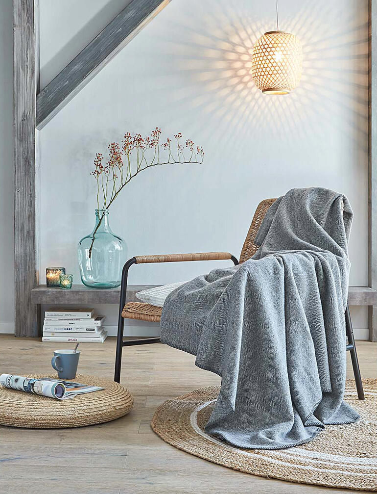 Couverture en laine polaire sur une chaise dans un salon moderne.