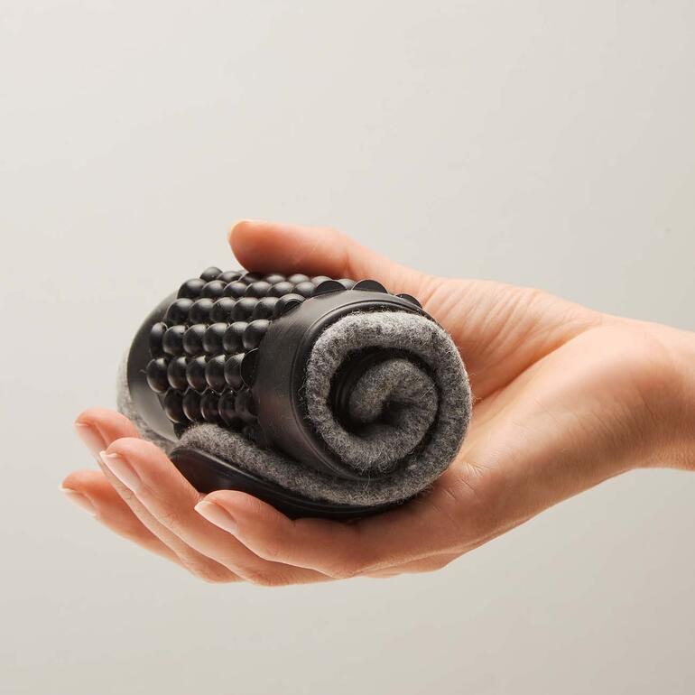 Pantoufle en feutre de laine a une forme simple et élégante, tenue dans la main.