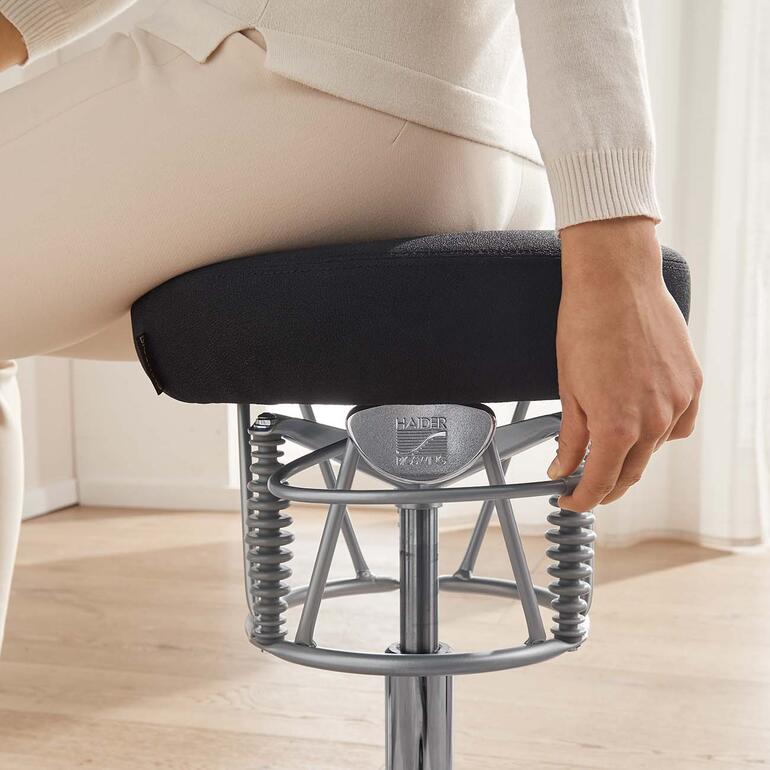 Gros plan sur la main d'une femme réglant un contrôle sur la chaise ergonomique.