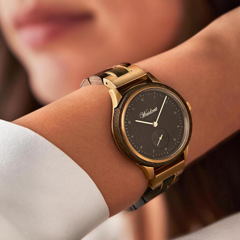 Montre élégante pour femme ou homme en chêne noir au poignet.