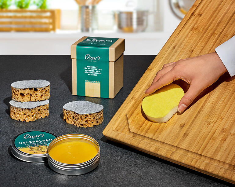 Set d'entretien du bois Oscar avec matériaux de nettoyage et d'entretien sur une planche en bois.