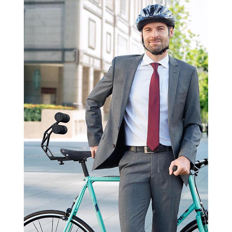 Homme en costume se tenant avec un vélo et le support arrière Tshobo à l'extérieur.