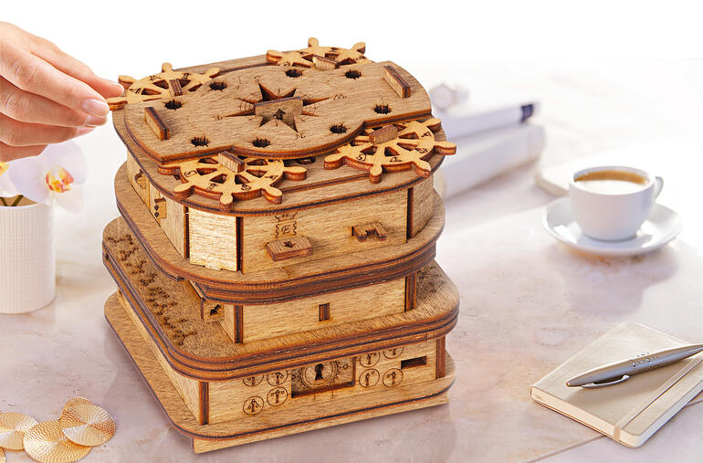 Boîte en bois avec plusieurs scènes de jeu et des énigmes sur le couvercle.