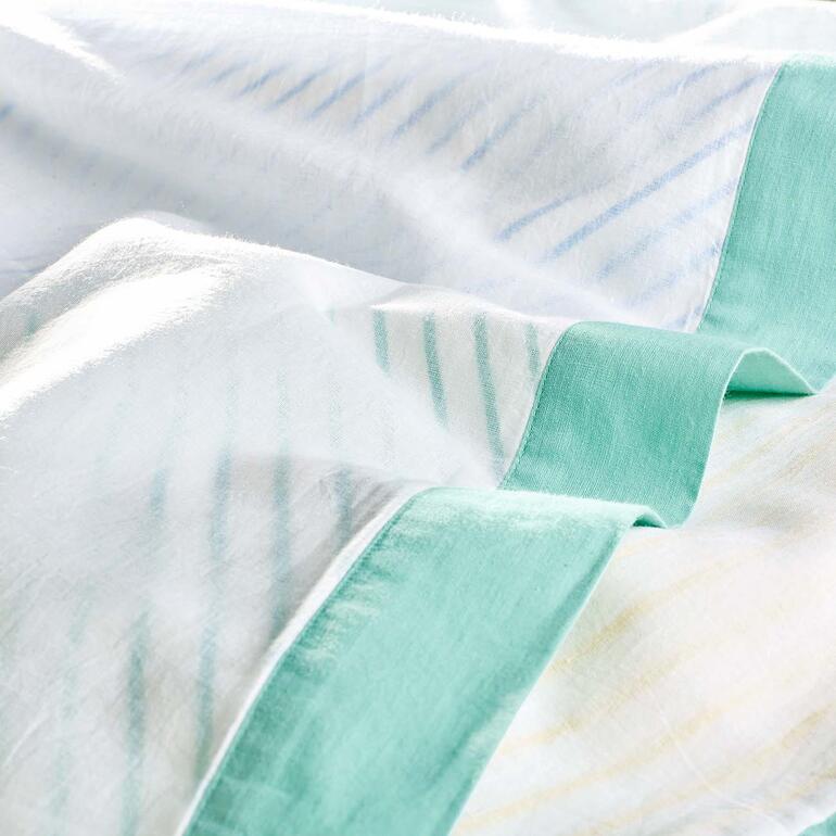 Confectionné à partir de 3 couches : couches supérieures et inférieures en tissu de coton légèrement transparent, couche centrale avec motif à rayures brillant joliment à travers les autres couches. Gros plan de la Breezyblanket avec une bordure verte.