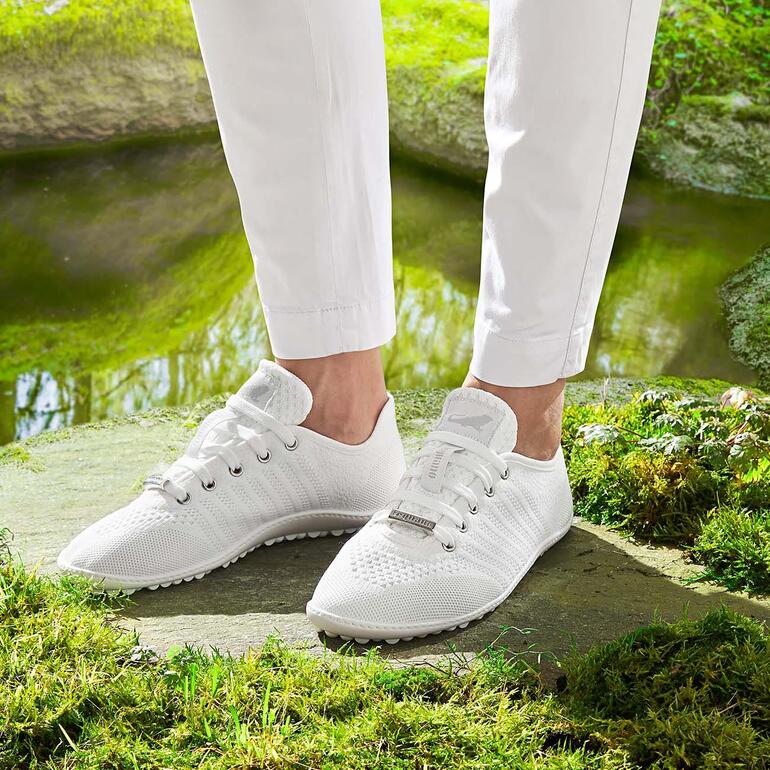 Baskets Barfuß-leguano en blanc, portées par une personne.