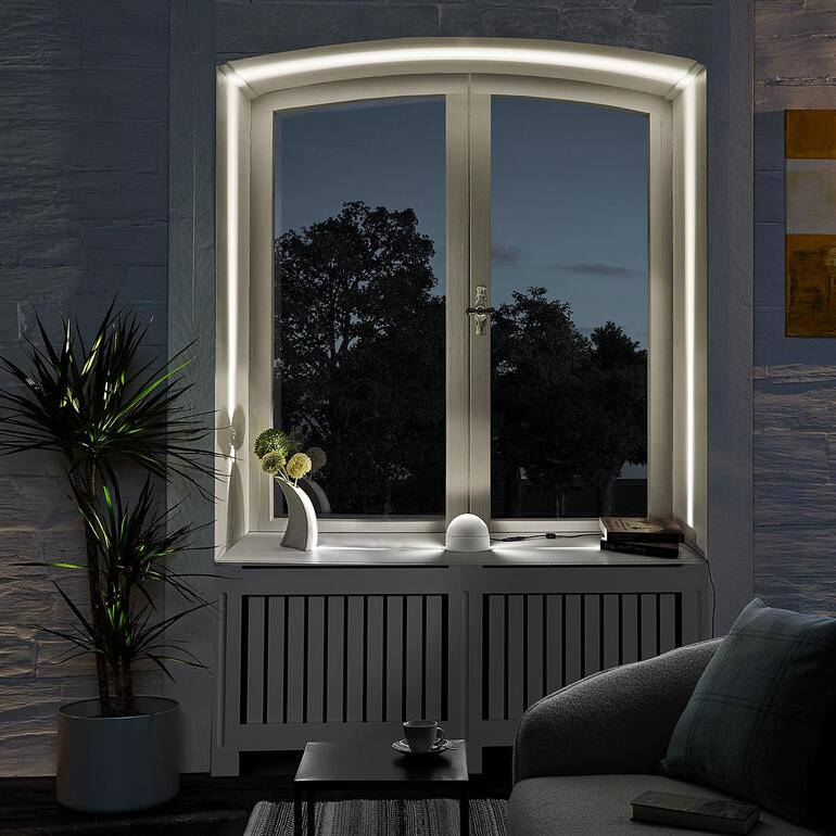 Lampe à effet LED à la fenêtre avec vue sur un jardin