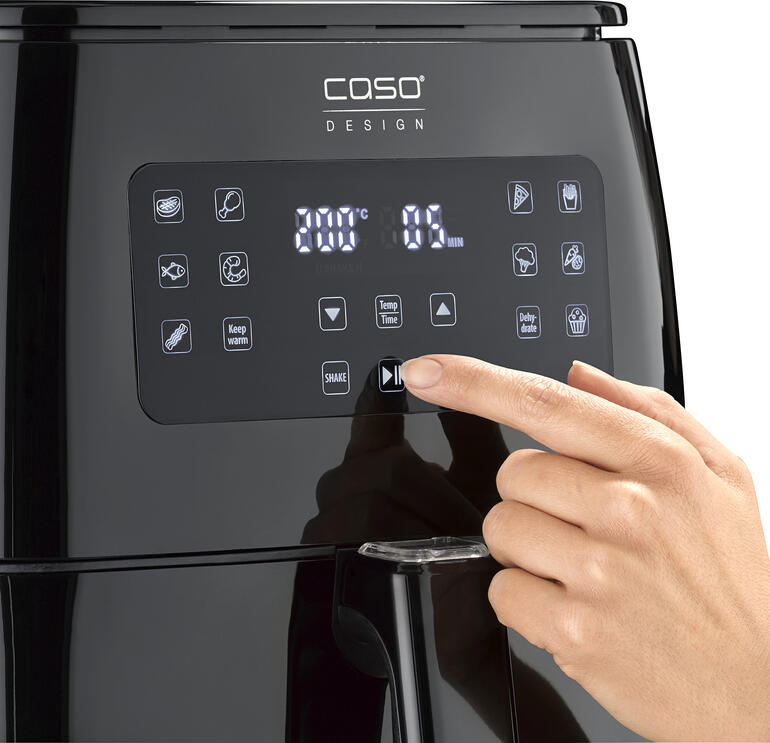 Gros plan sur le panneau de commande d'une friteuse à air chaud avec main