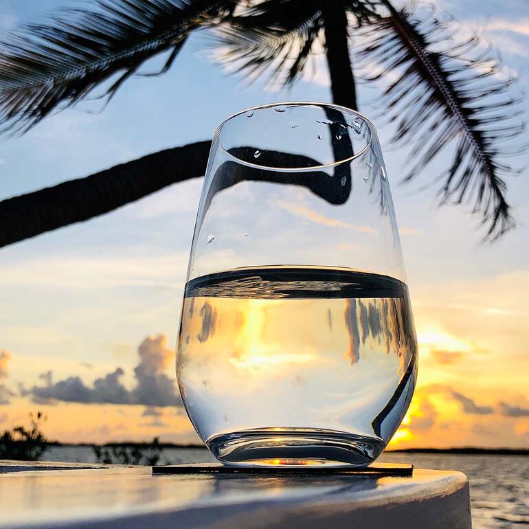 Verre d'eau claire, coucher de soleil en arrière-plan