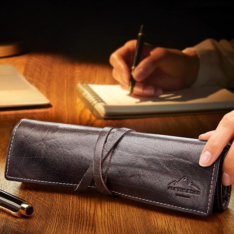 Étui brun en cuir avec des fournitures d'écriture pendant l'écriture.