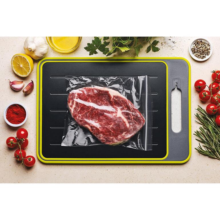 Morceau de viande sur une planche de décongélation.