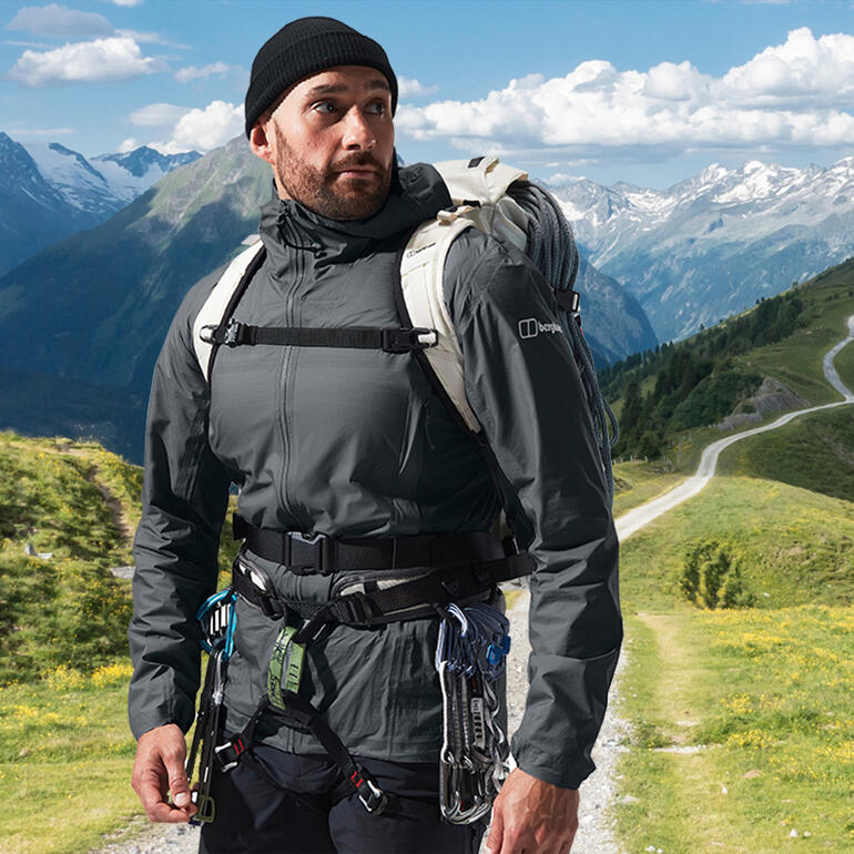 Homme en veste Berghaus Hyper Alpha devant des montagnes.