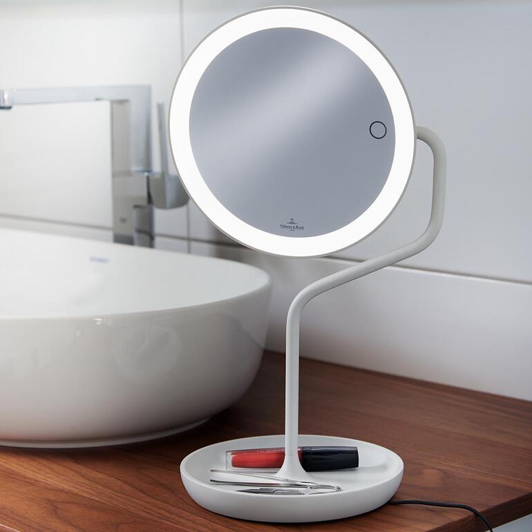 Miroir de maquillage avec éclairage LED et surface de miroir ronde sur une table.