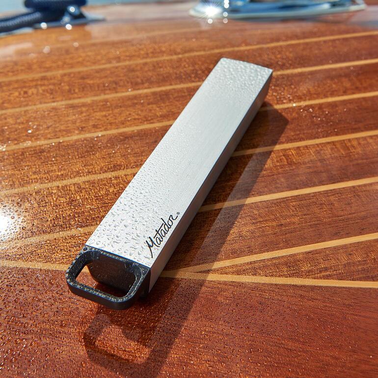 Boîte à pilules étanche sur une table en bois de bateau avec des gouttes d'eau.