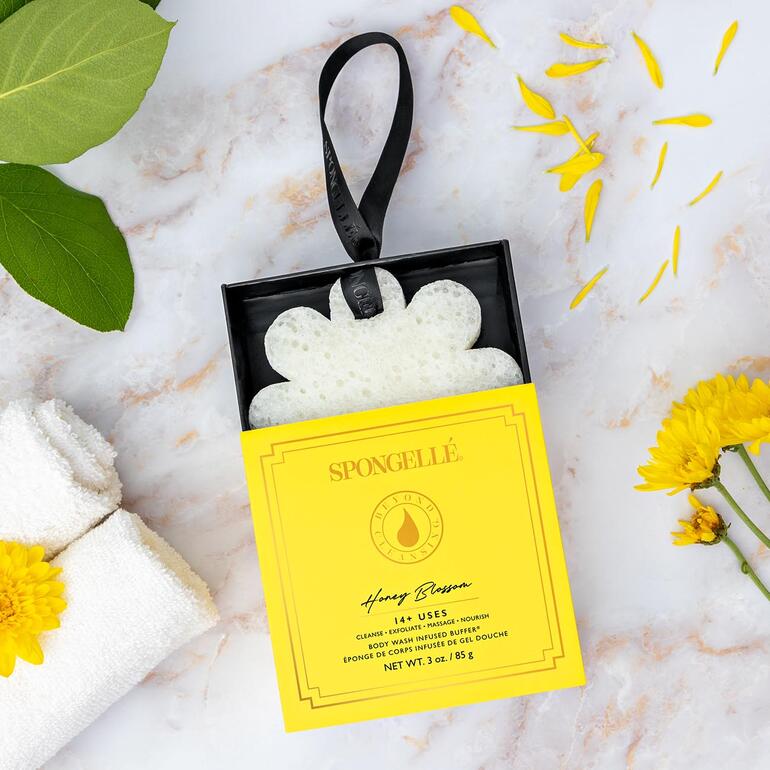 Éponge de beauté Spongellé dans un emballage jaune avec une décoration naturelle.