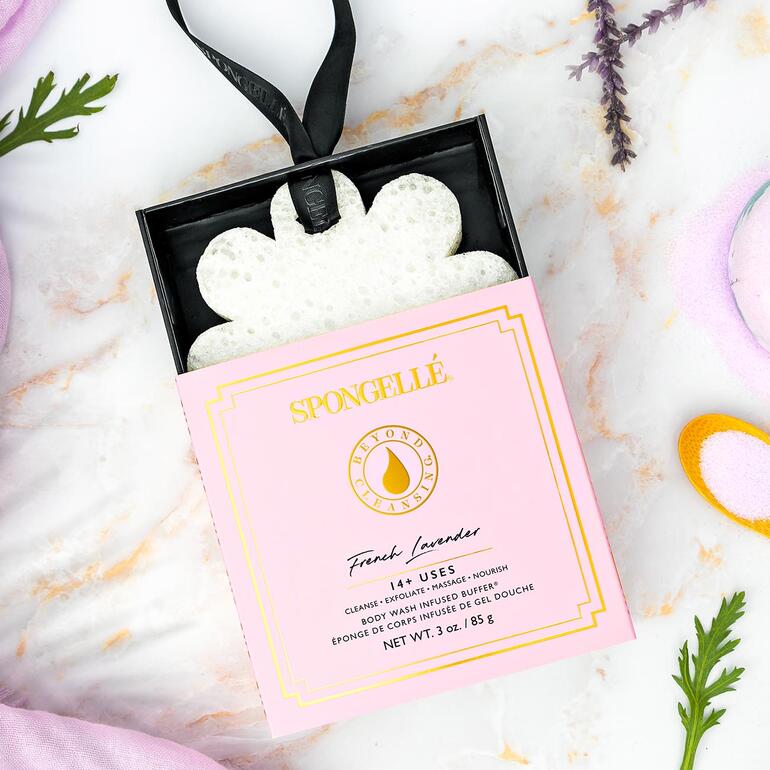 Éponge de beauté Spongellé en forme de fleur sur une décoration colorée.