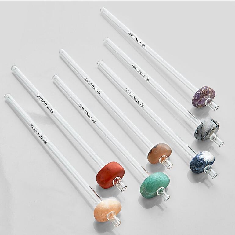 Le lot comprend 7 pierres précieuses de caractère : améthyste, quartz de tourmaline, sodalite, aventurine, calcite orange, cornaline et jaspe rouge. Set de pailles en verre avec sept pailles sur fond blanc.