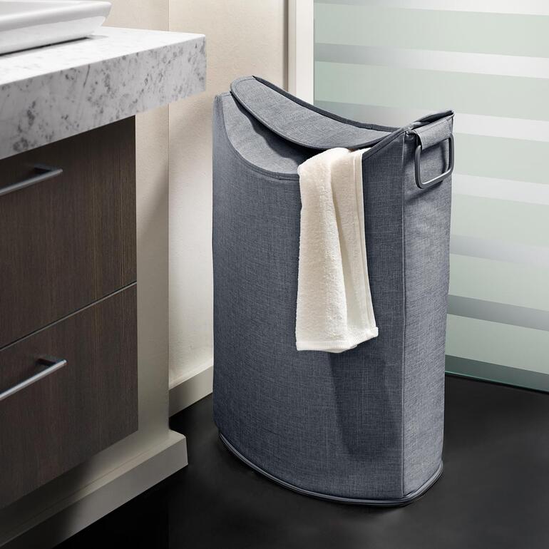 Panier à linge gris à côté d'un lavabo