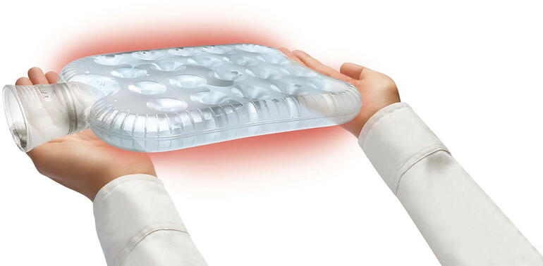 Mains tenant une bouillotte à bulles transparente.