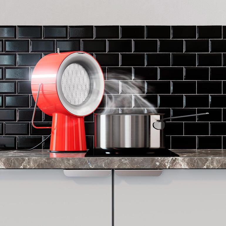 Appareil AirHood™ rouge avec nuages de vapeur au-dessus d'une casserole sur un plan de travail.