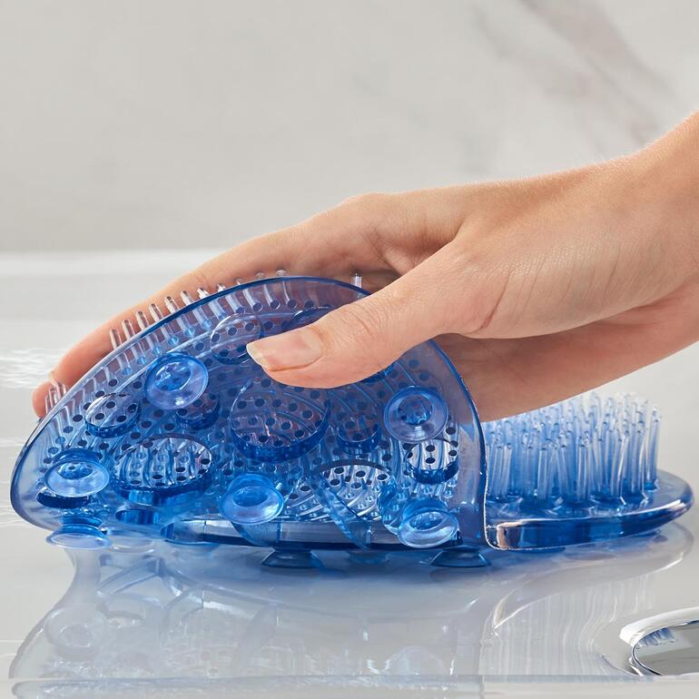 18 ventouses fixent la brosse de pédicure au bac à bouche ou à la paroi de la baignoire. Femme tenant la brosse de soin des pieds en silicone pour l'utiliser.