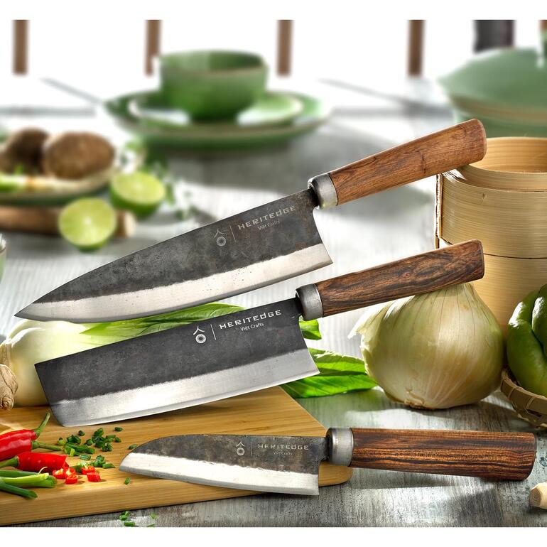 Trois couteaux de cuisine en acier au carbone sur une planche à découper