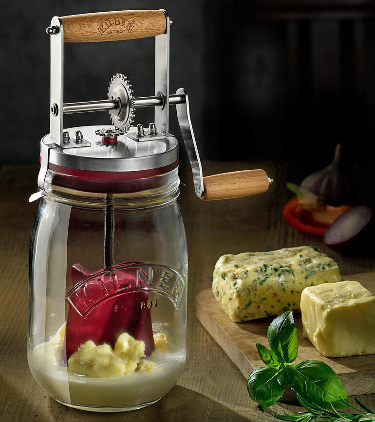 Pot de beurre avec manivelle sur une table en bois avec du beurre