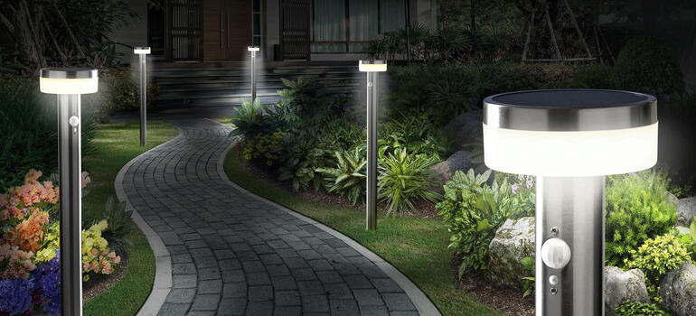 Lampes de jardin solaires intelligentes le long d'un chemin dans un jardin la nuit.