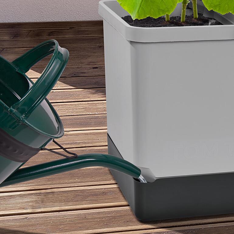 Arrosoir versant de l'eau dans la tour de plantes