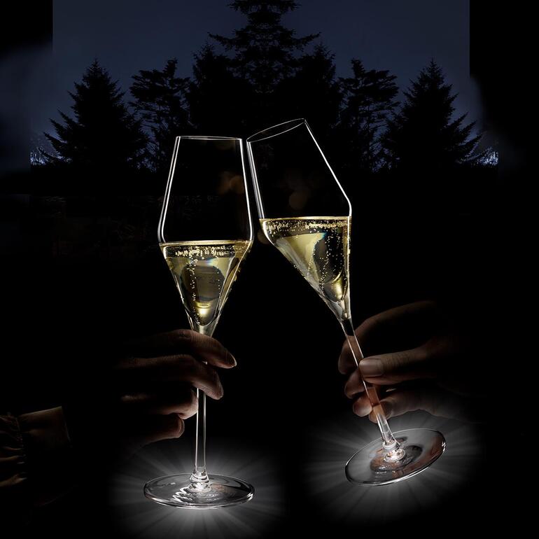 Deux flûtes à champagne lumineuses sur une table en plein air