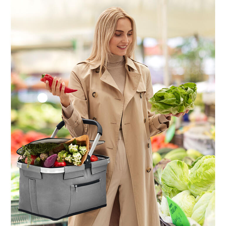Femme avec un panier de courses pliable en iso au supermarché.