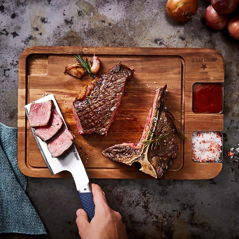 Un outil aux multiples talent pour également présenter parfaitement vos plats de manière appétissante. SteakChamp Flip & Cut sur une planche à découper en bois avec steak