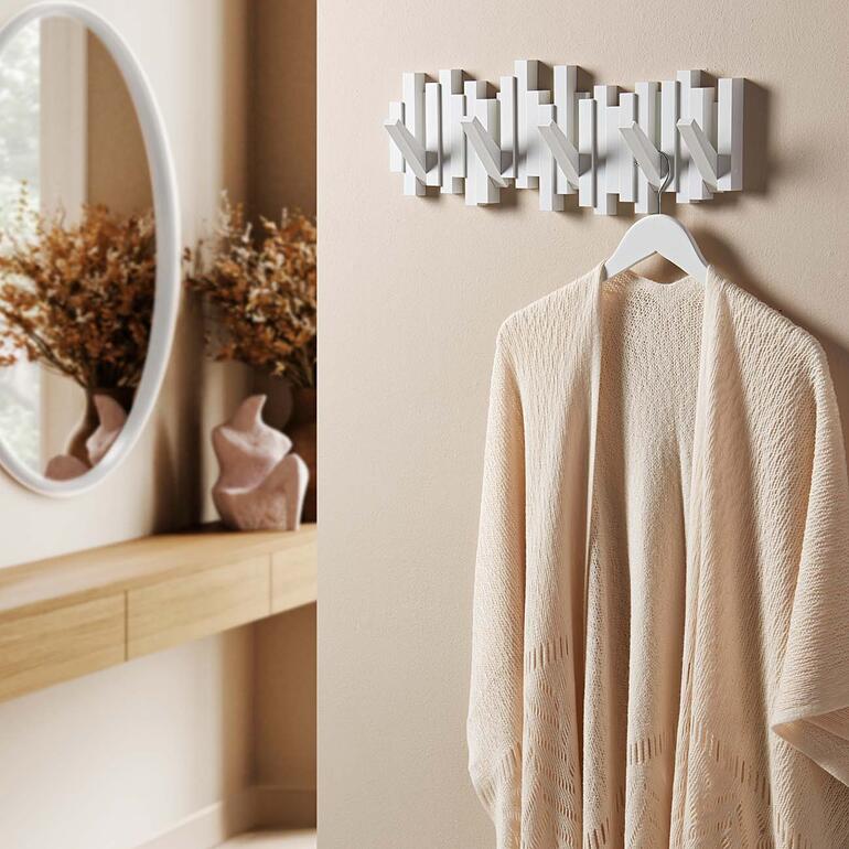 Porte-manteau mural en forme de clavier, avec un kimono beige à côté.