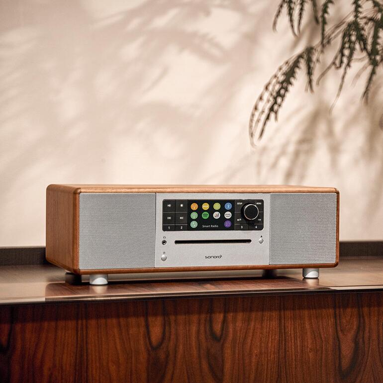 Sonoro PRESTIGE en couleur noyer sur une étagère avec de grands boutons.